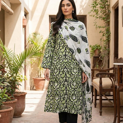 Woman wearing a green and black patterned outfit with a white dupatta in an outdoor setting.